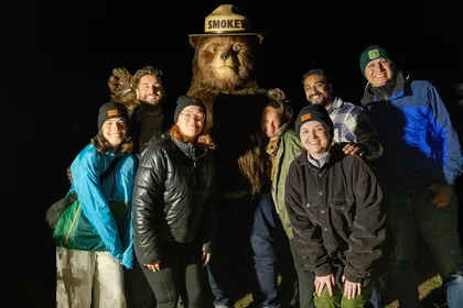 Equipo creativo posando con disfraz de Smokey Bear