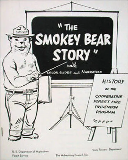 Dibujo de Smokey señalando hacia una pantalla en la que se lee: "La historia de el oso Smokey".