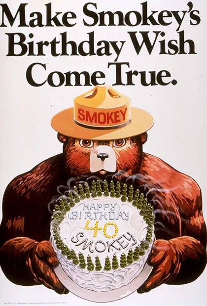 Cartel con el oso Smokey sosteniendo el pastel de su 40 aniversario en el que se lee: "Haz realidad el deseo de cumpleaños de Smokey".