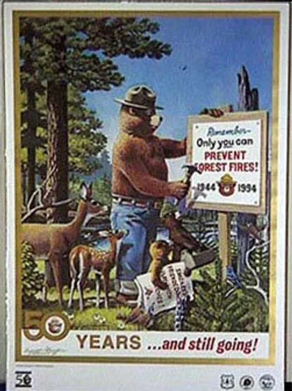 Smokey y sus amigos del bosque clavando un letrero que dice: "Recuerda ... solo tú puedes prevenir los incendios forestales".