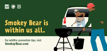 Persona que se deshace adecuadamente de las carbones calientes de una parrilla. Smokey aparece en el reflejo del coche delante de ellos. El texto dice "Smokey Bear está dentro de todos nosotros. Para consejos de prevención de incendios forestales, visite SmokeyBear.com"