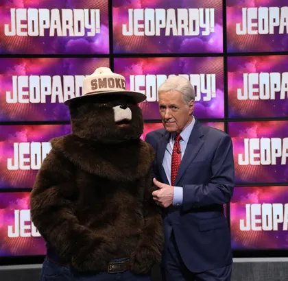 El oso Smokey y Alek Trebek frente a los paneles de Jeopardy
